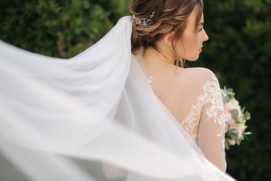 elegand-bride-white-wedding-dress-hold-bouquet-flowers-big-viel-background-green-bush.jpg